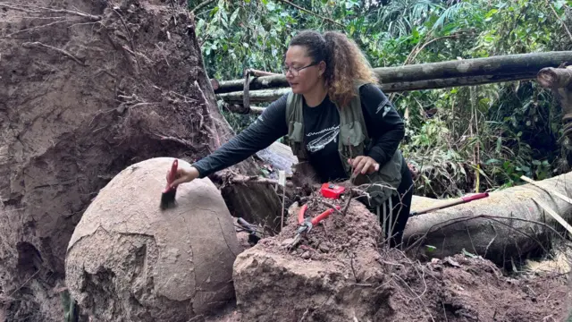 A arqueóloga Geórgea Layla Holanda trabalhando na remoção das urnas