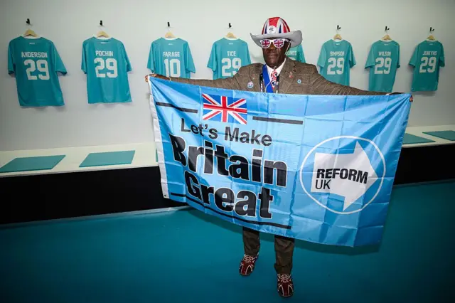 Reform Partisi'nin geçen ay Birmingham'da yapılan konferansına katılan bir partili, “Haydi Britanya’yı yeniden harika bir yer yapalım” yazılı bir bayrak taşıyor