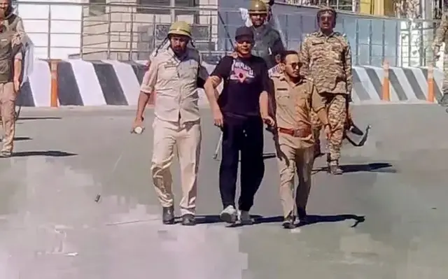 এক বিক্ষোভকারীকে ধরে নিয়ে যাচ্ছে পুলিশ