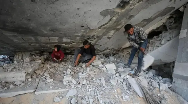 شابان وطفل في مبنى تعرض للقصف في غزة