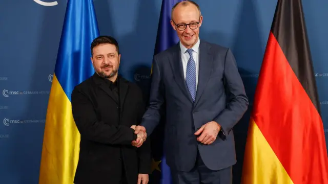 O presidente da Ucrânia, Volodymyr Zelensky, e o chanceler da Alemanha, Friedrich Merz, apertam as mãos antes de reunião bilateral durante a 62ª Conferência de Segurança de Munique