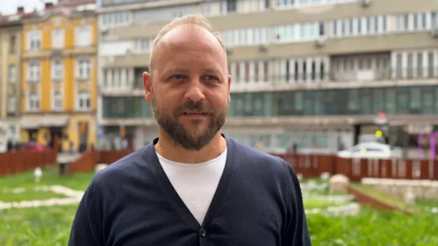 Денис Хусеинбеговић, директор је једне туристичке агенције која организује одлазак на Мундијал, плави мушкарац са брадом и у плавом џемперу гледа у камеру 