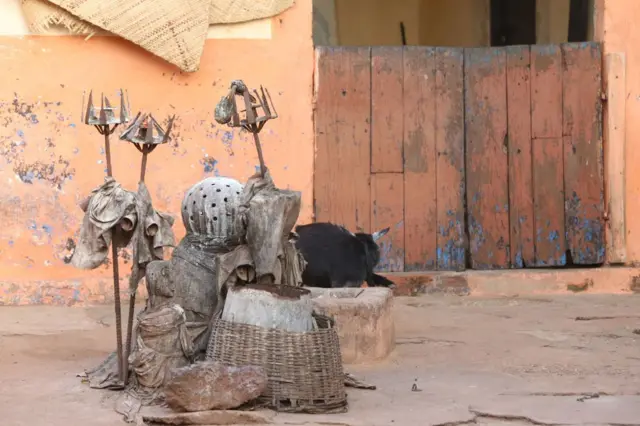 Des fétiches du milieu devant une maison