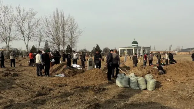 Тургундар көрүстөндөгү жакындарынын сөөгүн мүрзөнүн ичкери тарабына көчүрүп жатышат.