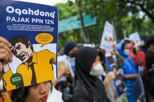 Sejumlah pengunjuk rasa membawa poster saat aksi penolakan PPN 12% di depan Istana Merdeka, Jakarta, Desember 2024.