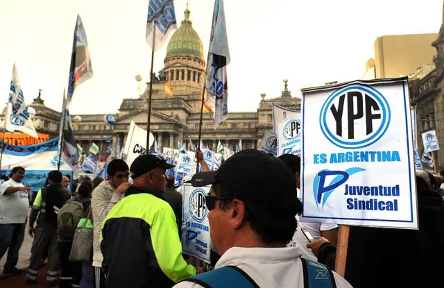Manifestantes frente al Congreso argentino con un cartel "YPF es argentina" durante el voto de diputados para expropiar la petrolera en 2012.