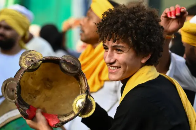 شاب يدق على الدف ضمن مجموعة من أتباع الطرق الصوفية في موكب الاحتفال بالمولد النبوي في القاهرة، في 15 سبتمبر/أيلول 2024.