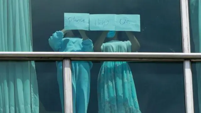 पनामा के होटल की खिड़की पर खड़ी दो लड़कियां मदद की अपील करती हुईं. 