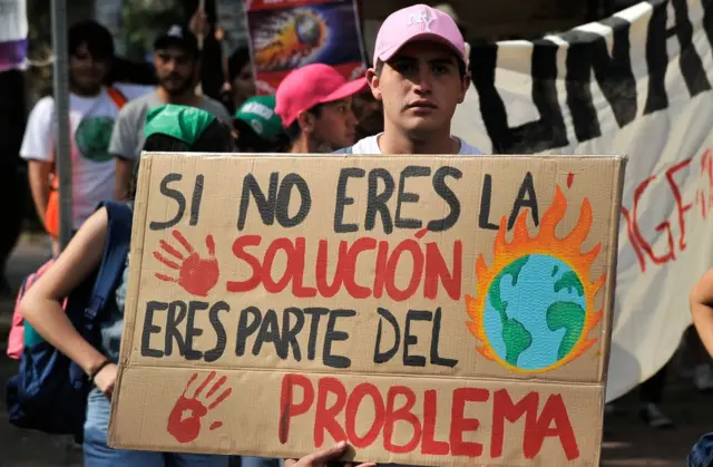 Protesta en México. Un adolescente tiene un cartel que dice "si no eres parte de la solución eres parte del problema"