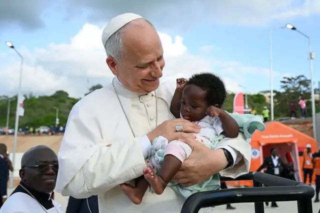 Le pape Léon XIV salue un enfant lors de sa visite au sanctuaire marial de Mama Muxim, en Angola, l'un des plus importants lieux de pèlerinage du pays, où il se joint aux fidèles pour la prière du chapelet le 19 avril 2026 à Muxim (Angola). 