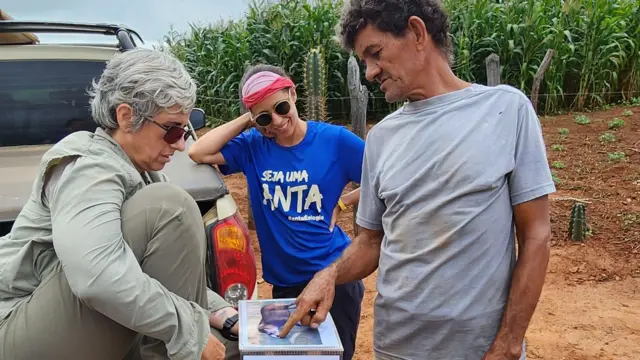 Pesquisadoras conversam com morador de comunidade local durante expedição