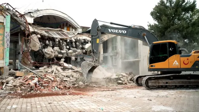 A digger clearing rubble in Ovakent