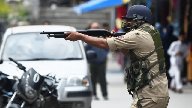 शुक्रवार को श्रीनगर के पुराने शहर में जामा मस्जिद के बाहर झड़प के दौरान एक पुलिसकर्मी प्रदर्शनकारियों पर पेलेट गन तानता हुआ (फ़ाइल फोटो)
