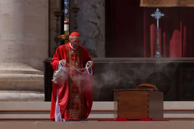 ካርዲናል በአስከሬን ሳጥኑ አጠገብ