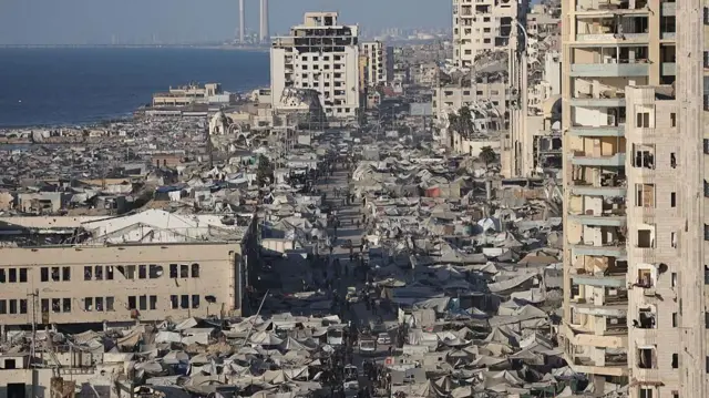 ওপর থেকে তোলা ছবিতে গাজার ভাঙাচোরা ভবন ও এসব ভবনের মাঝখানে অগণিত তাঁবু এবং একপাশে সাগর দেখা যাচ্ছে