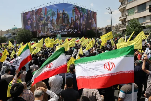 تجمع تعدادی از حامیان جمهوری اسلامی با پرچمهایی در دست