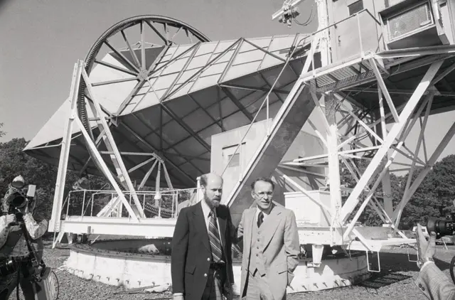 Robert W. Wilson y Arno A. Penzias de los Laboratorios Bell frente a la sensible antena utilizada para realizar investigaciones en radioastronomía y comunicaciones por satélite.