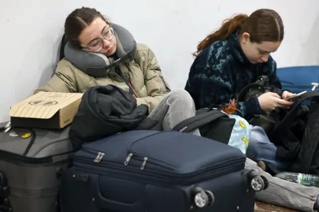 Passageiros sentados no chão