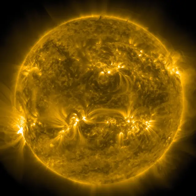 Photo of the Sun captured by the NASA Solar Dynamics Observatory, showcasing glowing golden and black patterns on the surface of the Sun.