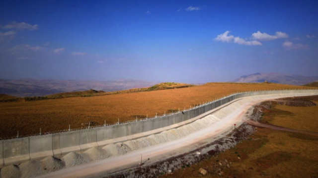 Muroéo brazinoconcreto na fronteira ao longo da paisagem com céu azul acima