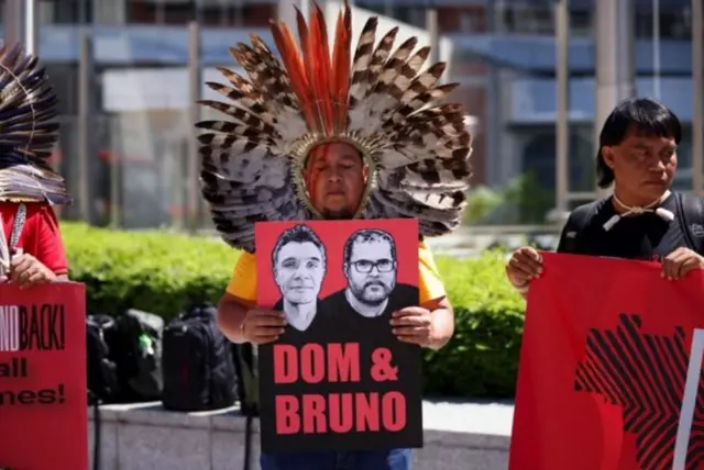 Indígenas com cartazes homenageando Dom e Bruno, inclusive com imagens dos dois homens