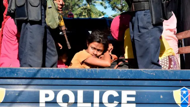 မလေးရှားကနေ နေရပ်(မြန်မာ)ပြန်ပို့ခံလိုက်ရတဲ့ ရိုဟင်ဂျာတွေကို စစ်တွေက ဒုက္ခသည်စခန်းဆီ စစ်ကောင်စီရဲတပ်ဖွဲ့ဝင်တွေက ပို့ဆောင်နေတဲ့မြင်ကွင်း (ပုံဟောင်း)