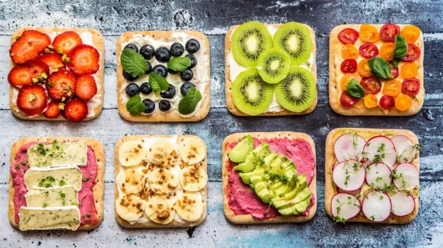 草莓、藍莓、酪梨、奶酪及其他食材鋪在麵包片上,排列成兩行