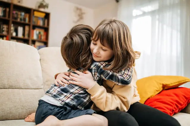Dos niñas dándose un abrazo. 