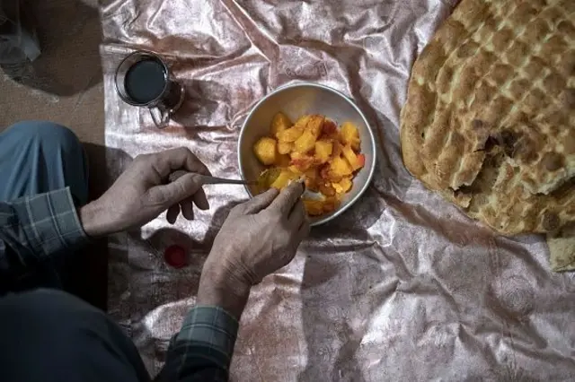 یک مرد در حال خوردن کچالو 