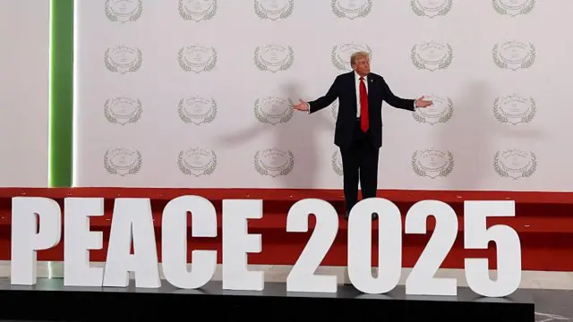 Trump, "Barış 2025" yazısının arkasında kameralara poz verirken