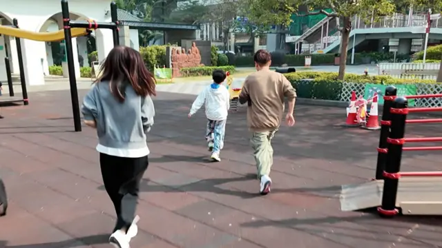 Aiden一家三口正在奔向一個玩樂設施