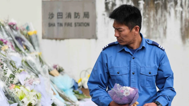 2025年12月2日，沙田消防局，一名消防員手捧鮮花。
