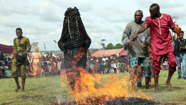 Ndị na-eti mmanwụ ha na mmanwụ nọ na-ele ka ọkụ na-agba n'ọhịa dịka ndị mmadụ gbakọrọ na-ele ihe na-eme 