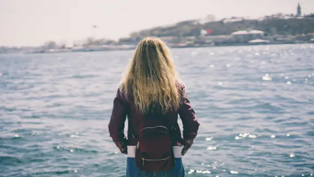 İstanbul'da denize doğru bakan bir genç kadının arkadan görüntüsü 