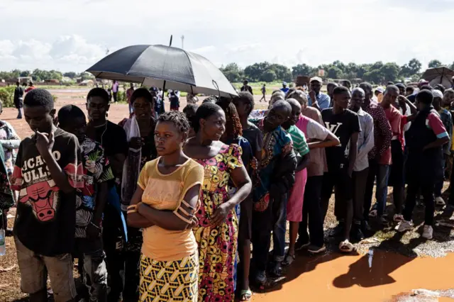 Des électeurs font la queue en attendant de voter dans un bureau de vote à l'école Bwakya à Lubumbashi le 21 décembre 2023.