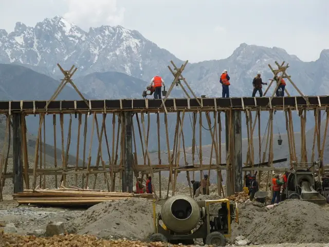  کارگران بر فراز یک پل در حال سمنت‌ریزی دیده می‌شوند