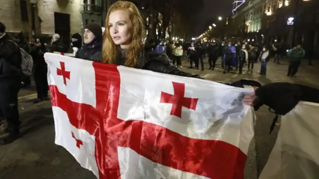 Manifestante con bandera de Georgia.