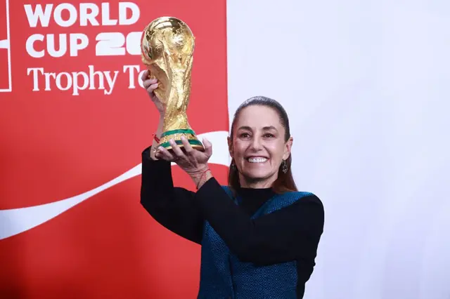 La presidenta de México Claudia Sheinbaum sostiene la Copa Mundial de fútbol