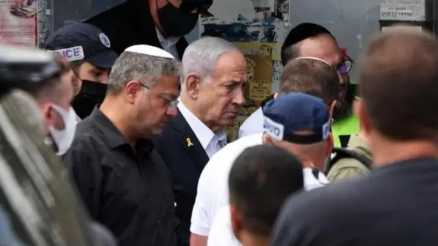 Benjamin Netanyahu e Itamar Ben-Gvir no local do ataque, em meio a outras pessoas