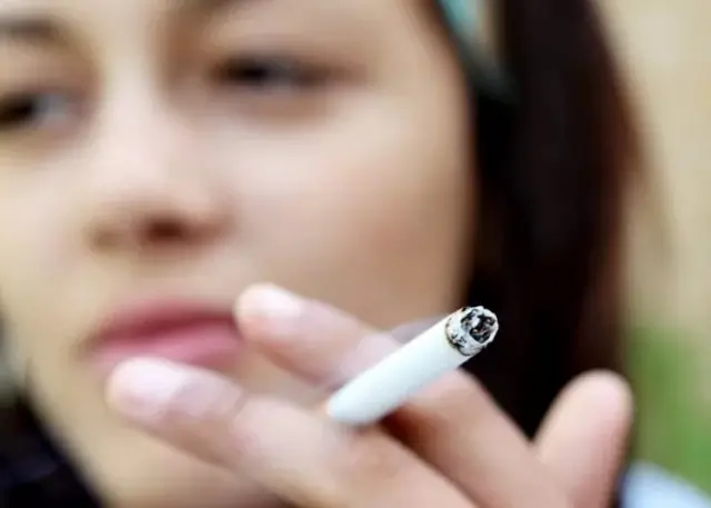 Femme tenant une cigarette