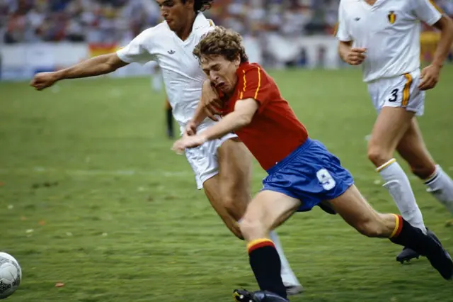 İspanyol futbolcu Emilio Butragueño, Dünya Kupası maçında Belçikalı rakibine müdahale etmeye çalışıyor