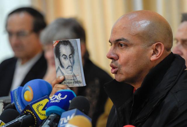 Clíver Alcalá muestra un libro en una rueda de prensa