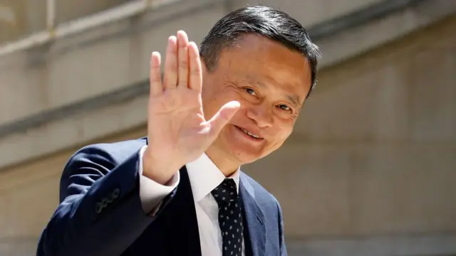 Jack Ma, de terno, acenando