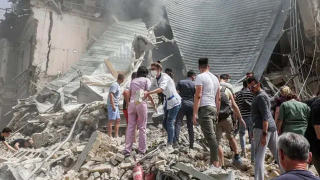 Una cadena humana remueve los escombros del hospital en Kyiv