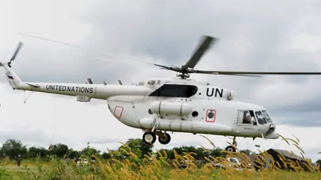 One white helicopter dem write wit di United Nations' initials.