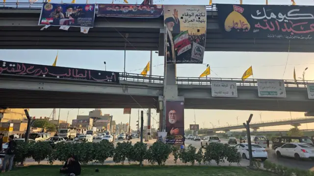 جسر في مدينة النجف علقت عليه رايات صفراء وصورة علي خامنئي وصور قادة عسكريين وعلماء دين شيعة