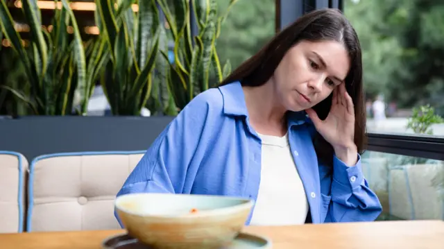 আকাশী রংয়ের শার্ট পরা একজন নারী