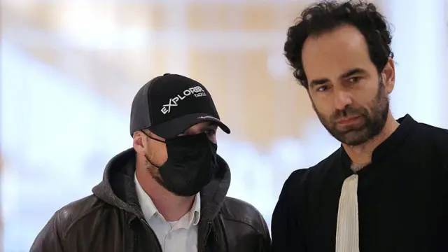 Дилан Билёд в черной бейсболке и черной маске на лице