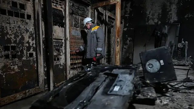 Працівник ДТЕК оглядає електростанцію після російського обстрілу