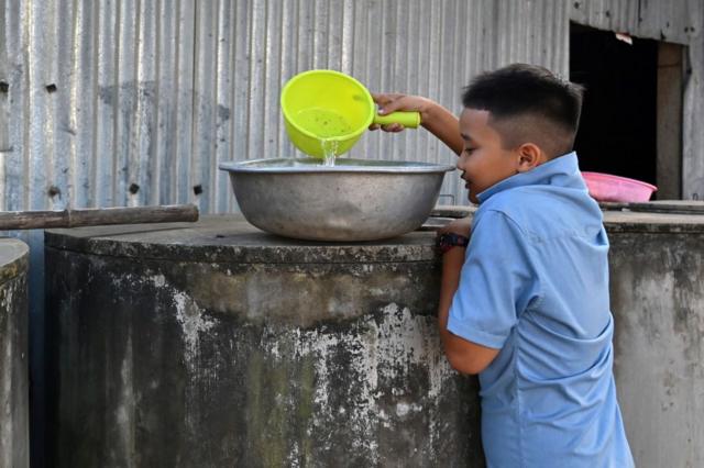 Ảnh chụp một cậu bé dùng nước sạch của gia đình tại tỉnh Bến Tre, vào ngày 19/3/2024.
